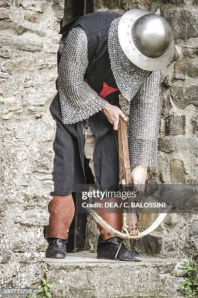 Crusader with kettle hat loading a crossbow, 13th-14th century. Historical reenactment.
