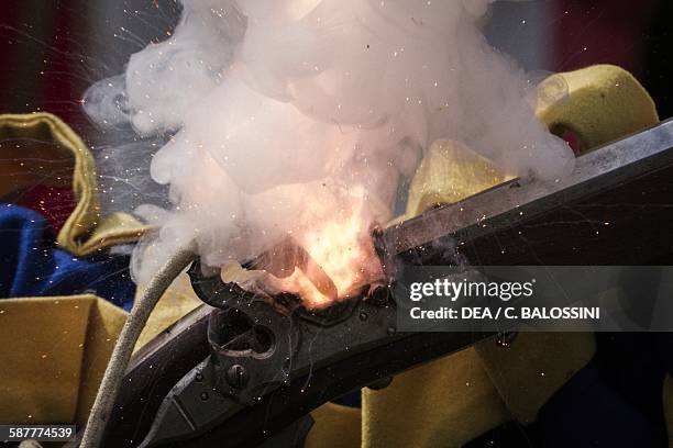 Gunpowder sparked in the priming pan of a matchlock arquebuse, 16th century. Historical reenactment.