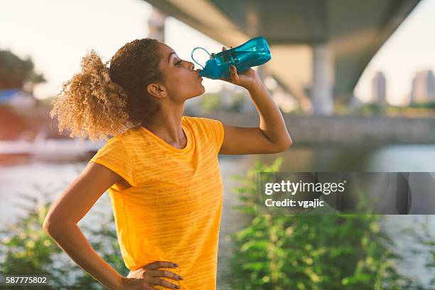 latina runner - drinking water outside stock pictures, royalty-free photos & images