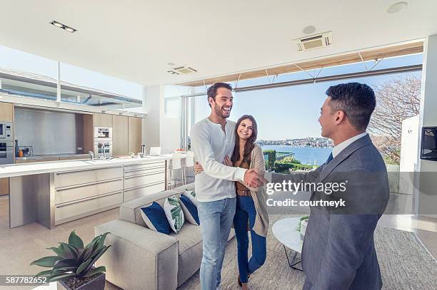 agente immobiliare con coppia in casa di lusso. - casa in esposizione foto e immagini stock