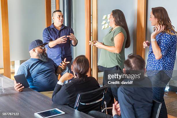 successful maori pacific islander business woman leading a team meeting - meeting community stockfoto's en -beelden