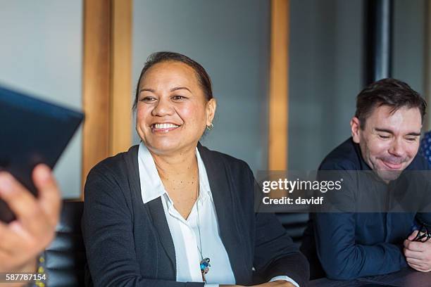 successful maori pacific islander business woman leading a team meeting - new zealand maori people talking stock pictures, royalty-free photos & images