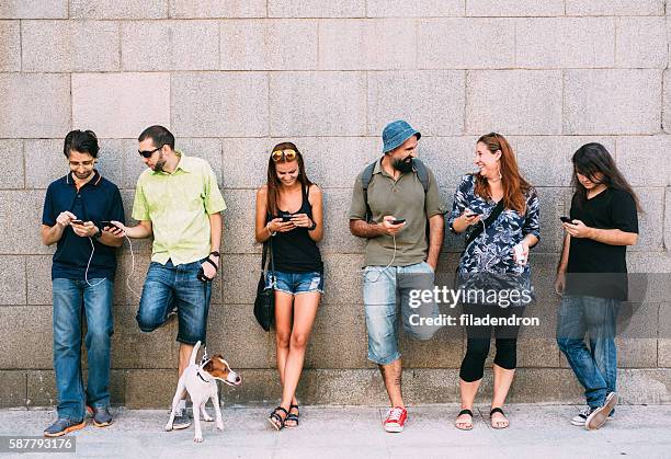 versenden von sms in der stadt - generationsunterschied stock-fotos und bilder