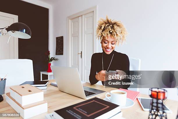 joven afroamericana en un home office - pleased laptop fotografías e imágenes de stock