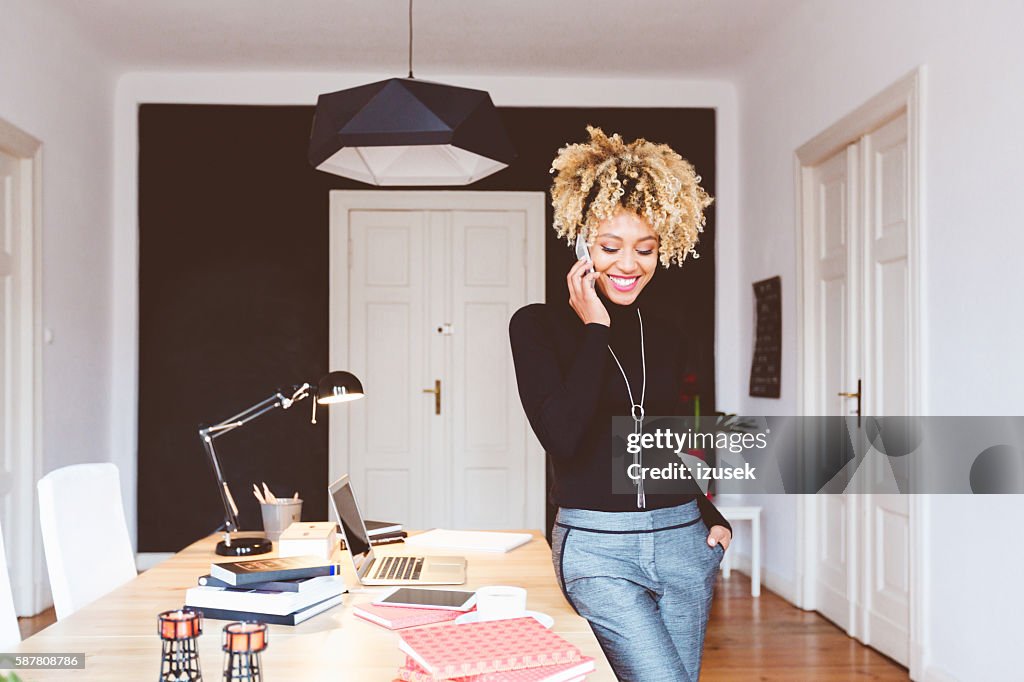 Feliz afro-americana jovem em um home office