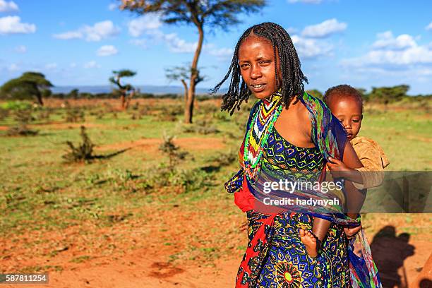 young mother  from borana tribe carrying her baby, ethiopia, africa - african tribal culture 個照片及圖片檔