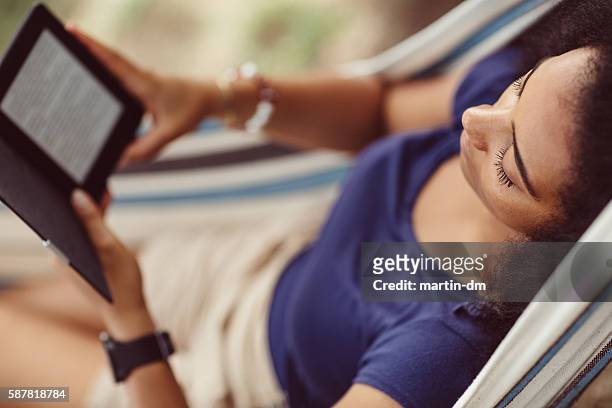 woman resting in a hammock - e reader stock pictures, royalty-free photos & images
