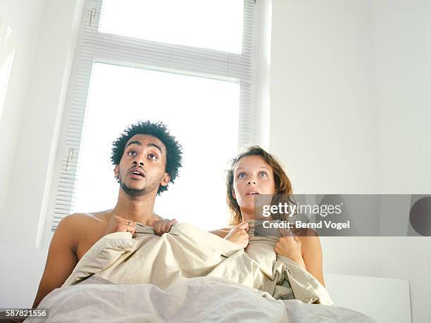 man and woman with surprised expression - colpevolezza foto e immagini stock