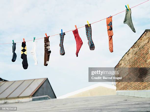 socks hanging from clothesline - socks photos et images de collection