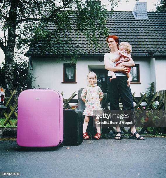 mother and girls with suitcases, standing in front of a house - waiting outside stock pictures, royalty-free photos & images