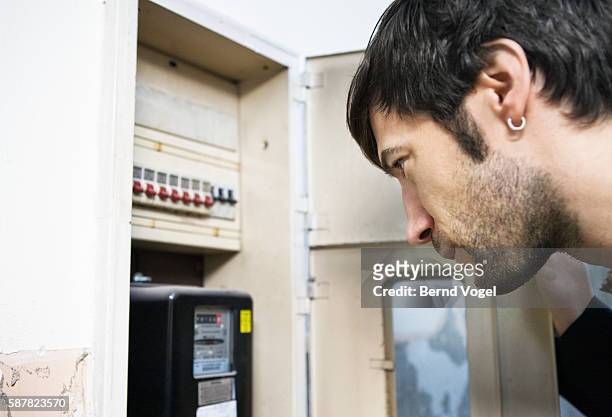 man looking at utility meter - electricity meter stock pictures, royalty-free photos & images