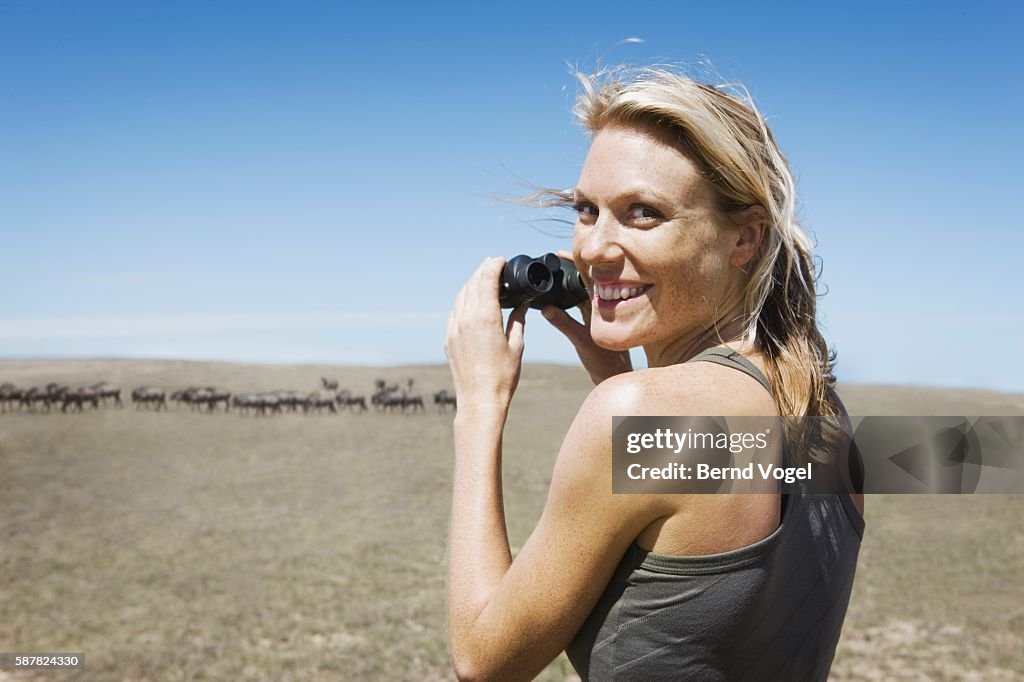 Woman Watching Herd of Wildebeests