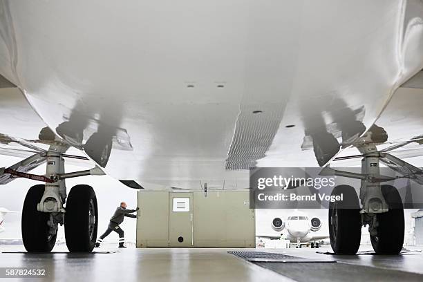man opening doors in airplane hangar - landing gear stock pictures, royalty-free photos & images