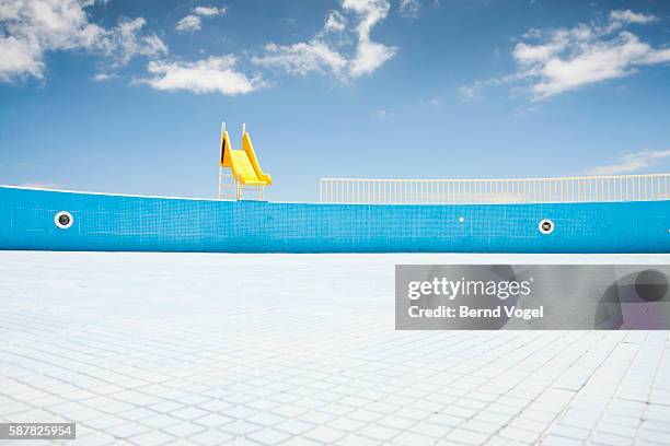 abandoned pool with yellow slide - abandoned playground stock pictures, royalty-free photos & images