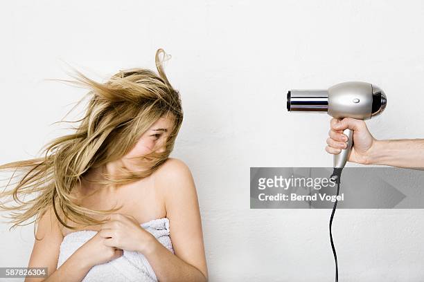 woman having her hair dried - brushing photos et images de collection