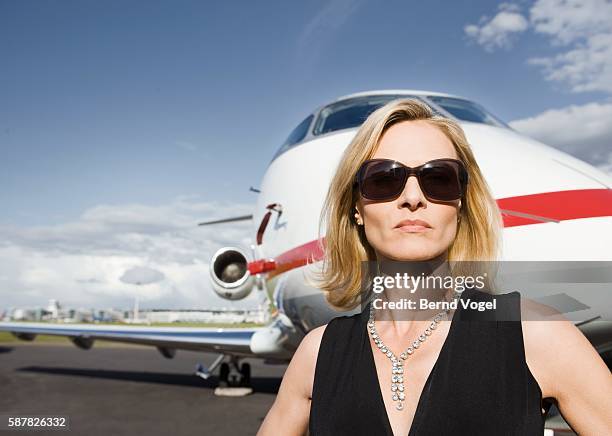 woman standing outside of corporate airline - vantarsi foto e immagini stock