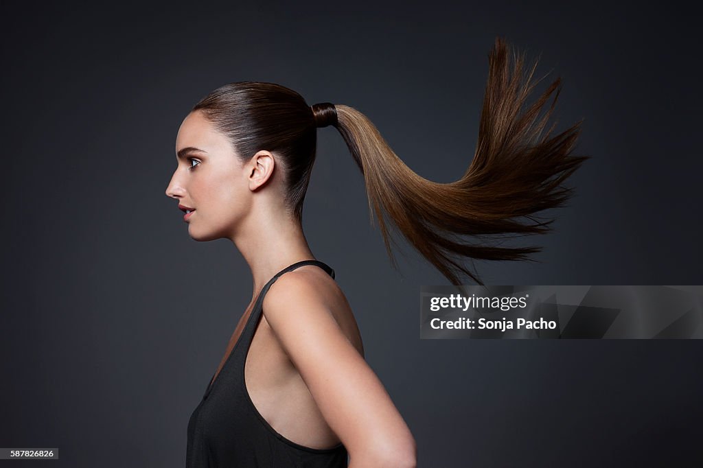 Studio shot of young woman tossing hair