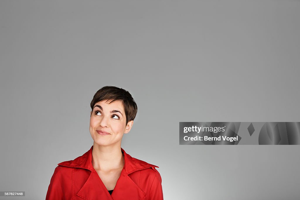 Studio portrait of mid adult woman wearing red coat