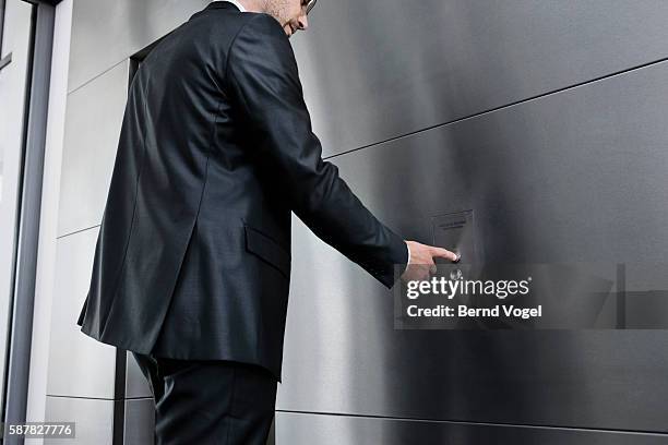 businessman pushing elevator button - pressing elevator button stock pictures, royalty-free photos & images