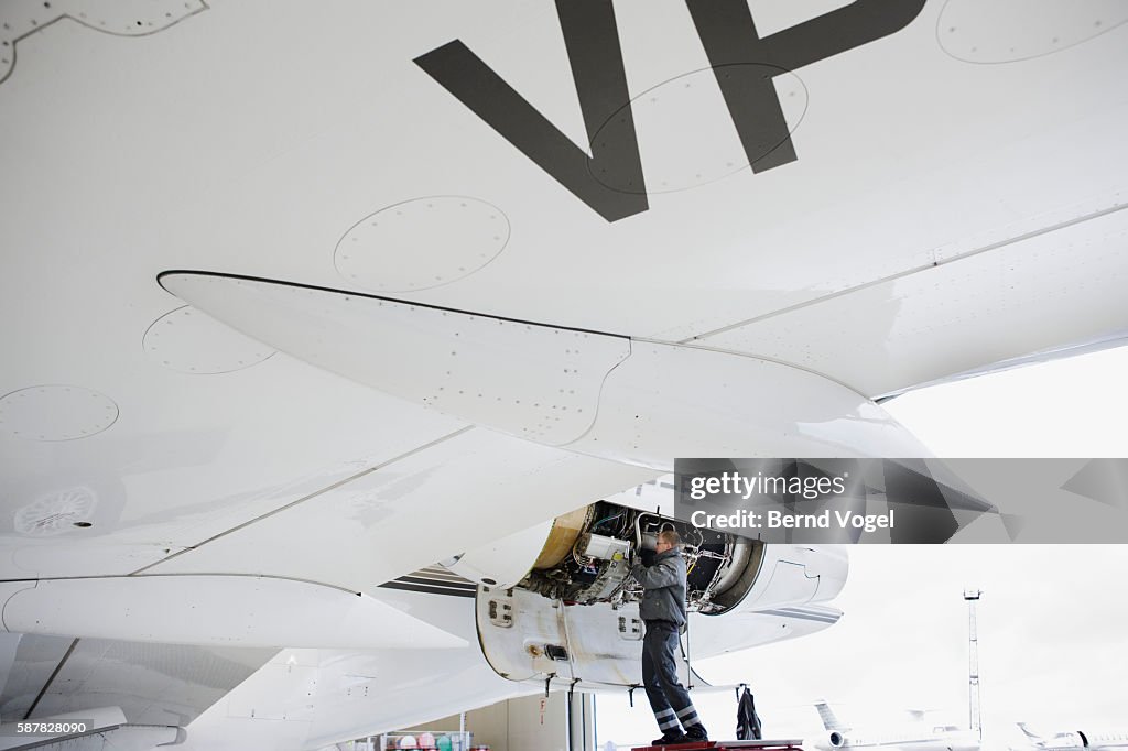 Aviation mechanic working on jet engine