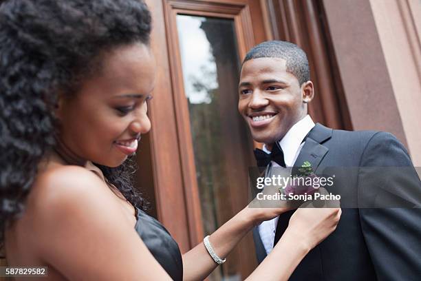 woman adjusting man's boutonniere - proms stock pictures, royalty-free photos & images