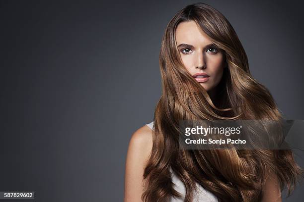studio portrait of young woman with long brown hair - thick white women fotografías e imágenes de stock