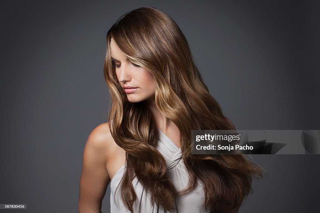 Studio portrait of young woman with long brown hair