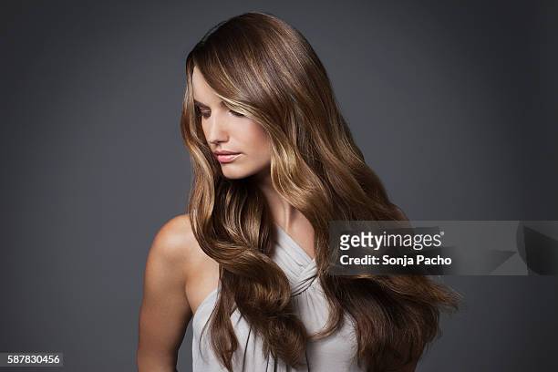studio portrait of young woman with long brown hair - wavy brown hair stock pictures, royalty-free photos & images