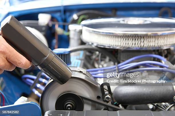 a mechanic tuning a car engine with a timing light. - car tuning stock pictures, royalty-free photos & images