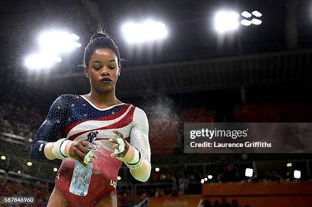 Gabrielle Douglas of the United States sprays in preparation for competing on the uneven bars during the Artistic Gymnastics Women's Team Final on...