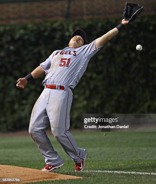 Ji-Man Choi of the Los Angeles Angels stumbles as he tries to catch a ball hit by Anthony Rizzo of the Chicago Cubs in the 5th inning at Wrigley...
