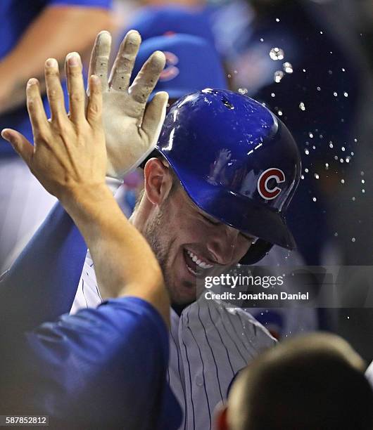 Kris Bryant of the Chicago Cubs is doused with water as he celebrates with teammates in the dugot after hitting a solo home run in the 5th innning...