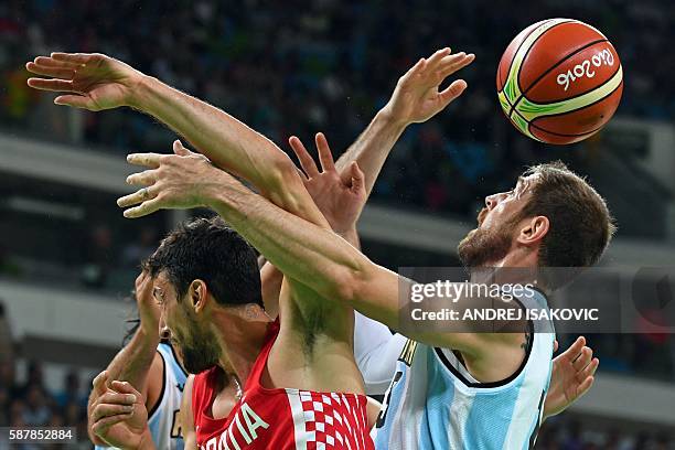 Croatia's point guard Roko Ukic and Argentina's small forward Andres Nocioni go for a rebound during a Men's round Group B basketball match between...