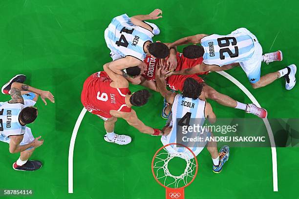 An overview shows Croatia's centre Darko Planinic holding on to the ball surrounded by Argentina's shooting guard Carlos Delfino, Croatia's forward...