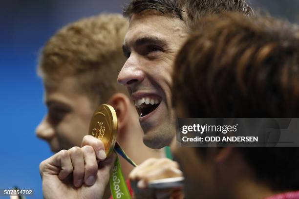 S Michael Phelps poses on the podium with his gold medal after he won the Men's 200m Butterfly Final during the swimming event at the Rio 2016...