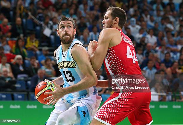 Andres Nocioni of Argentina moves the ball against Bojan Bogdanovic of Croatia during a preliminary round basketball game between Croatia and...