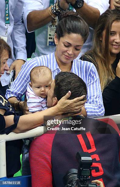 Gold medalist Michael Phelps of USA kisses his 3 months old son Boomer Phelps while his fiancee Nicole Johnson looks on following the medal ceremony...