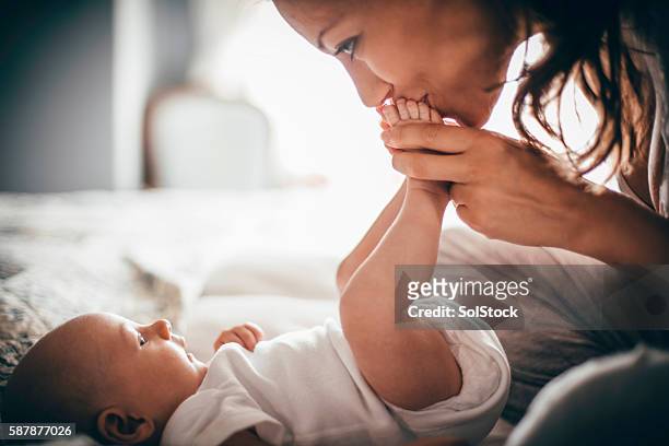cariñoso madre - kissing feet fotografías e imágenes de stock