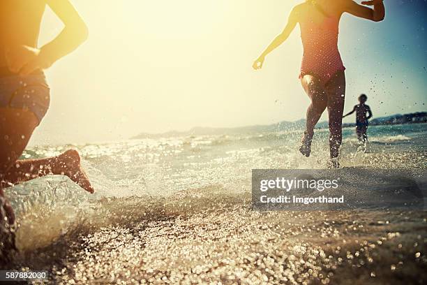 brothers and sister running on beach on sunset - mediterranean sea stock pictures, royalty-free photos & images