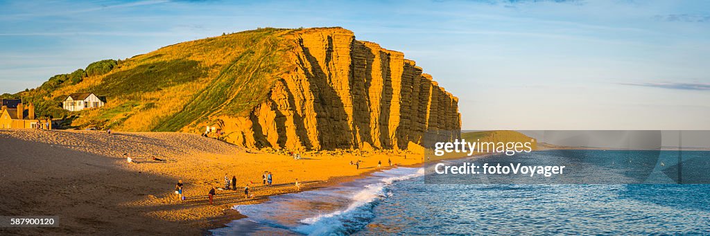Familias de pescadores en la playa bajo los acantilados dorados de West Bay Dorset