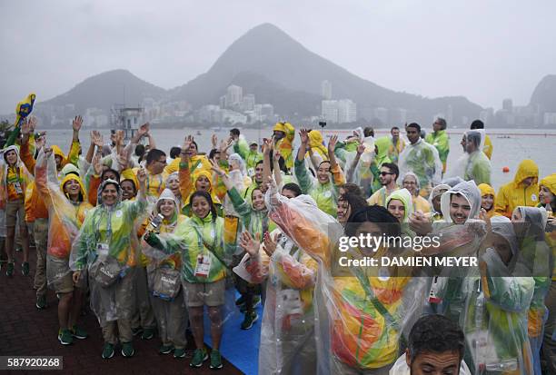 Volunteers sing and dance at the Lagoa stadium following the cancellation of today's rowing competition, due to bad weather, during the Rio 2016...