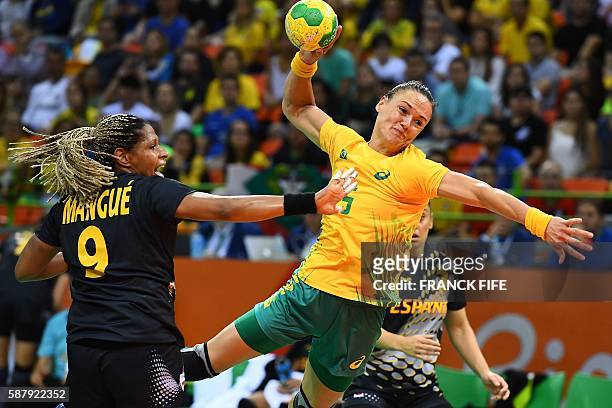 Brazil's pivot Daniela Piedade jumps to shoot past Spain's left back Marta Mangue Gonzalez during the women's preliminaries Group A handball match...