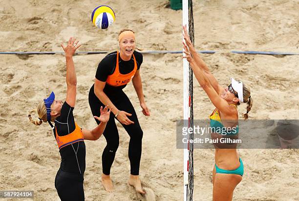 Marleen van Iersel of Netherlands vies with Louise Bawden of Australia as Madelein Meppelink of Netherlands looks on during their women's prelimiary...