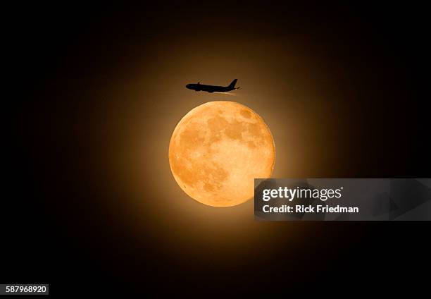 An airplane appearing to fly above the Super moon near Boston, MA on June 23, 2013.