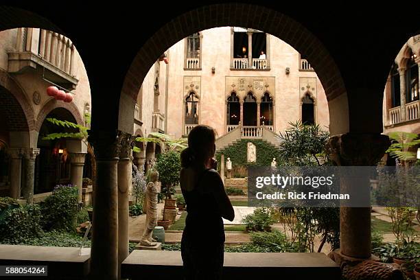 Visitor has a moment alone in the garden courtyard of the Isabella Stewart Gardner Museum in Boston.