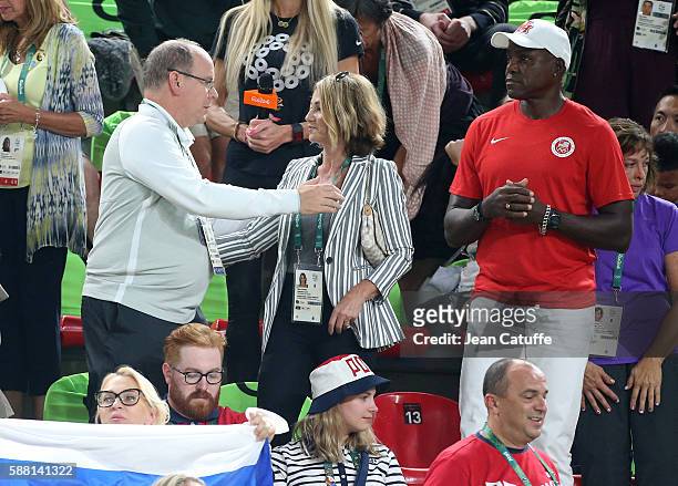 Prince Albert II of Monaco kisses Nadia Comaneci goodbye while Carl Lewis looks on during the women's team final in Artistic Gymnastics at Rio...