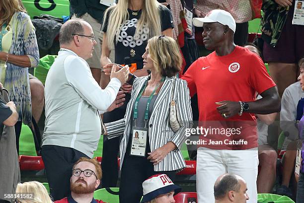 Prince Albert II of Monaco greets Carl Lewis while Nadia Comaneci looks on during the women's team final in Artistic Gymnastics at Rio Olympic Arena...