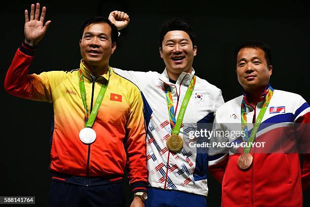 Silver medallist Vietnam's Xuan Vinh Hoang, gold medal winner South Korea's Jin Jongoh and bronze medallist North Korea's Kim Song Guk stand on the...