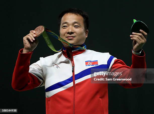 Bronze medalist Song Guk Kim of China poses on the podium following the 50m pistol event on Day 5 of the Rio 2016 Olympic Games at the Olympic...