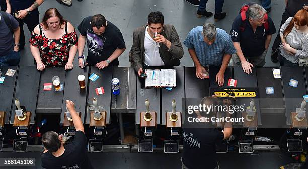Bar staff serve visitors at the CAMRA Great British Beer festival at Olympia London exhibition centre on August 10, 2016 in London, England. The five...